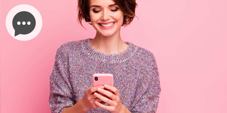 Attractive woman laughing at the message she’s received on her mobile.